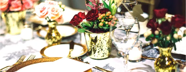 A decorated wedding table with gold accents and flowers, representing event services on an Asian wedding directory.
