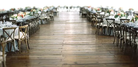 A long, decorated aisle between wedding reception tables, showing venues on an Asian wedding directory.