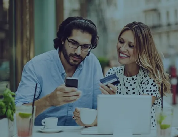 Happy couple shopping online using a phone and card, highlighted by an Asian directory website.