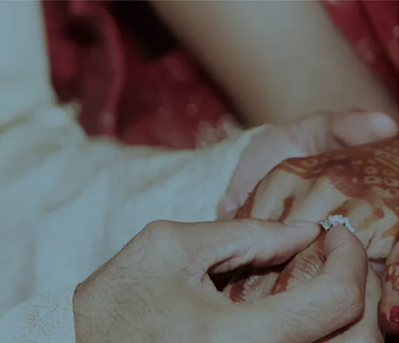 Man places a wedding ring on a woman's finger, promoting an Asian wedding market.