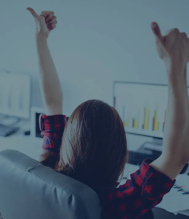 A person with raised arms at a desk, symbolizing success for an Asian directory website.